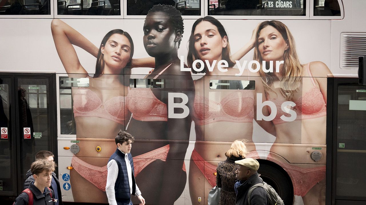 Four women and the sentence &#039;Love Your Boobs&#039; are seen on the side of a London bus