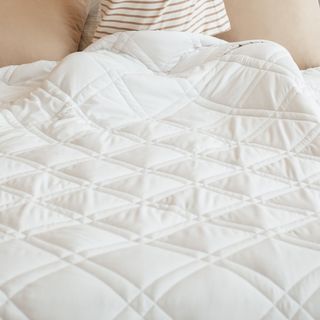 White quilted weighted blanket on bed