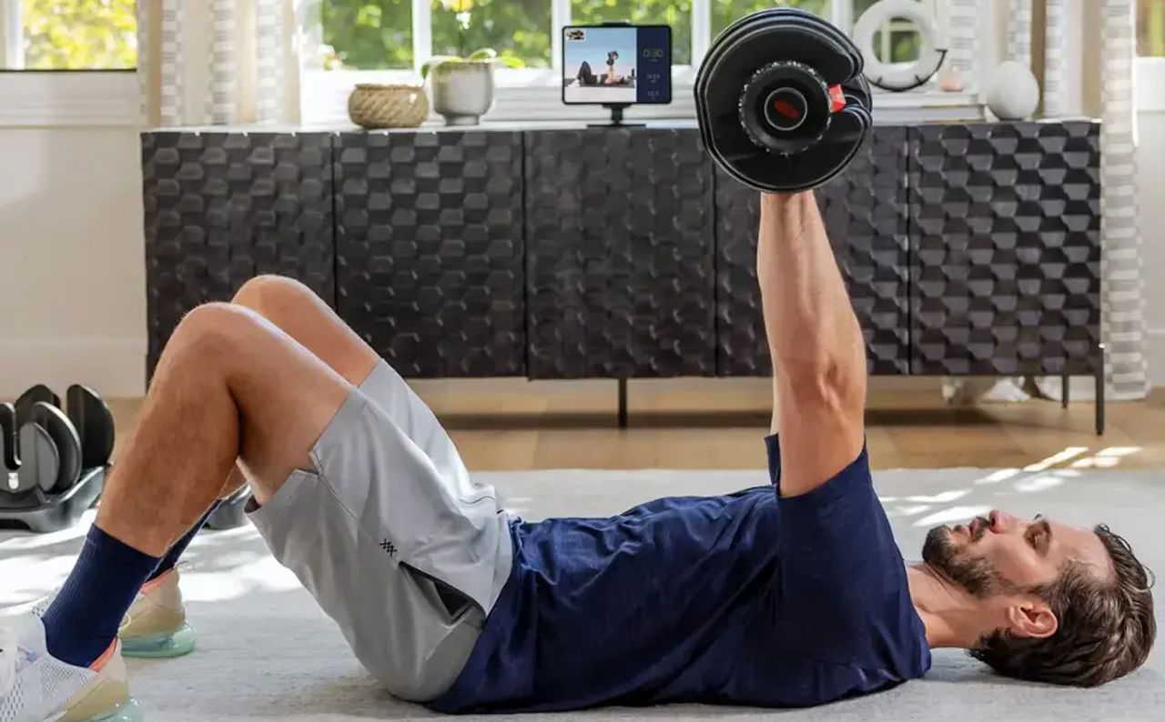 Male using the Bowflex SelectTech 552 Dumbbells at home