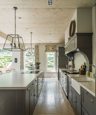 Traditional kitchen with taupe cabinetry and travertine flooring.