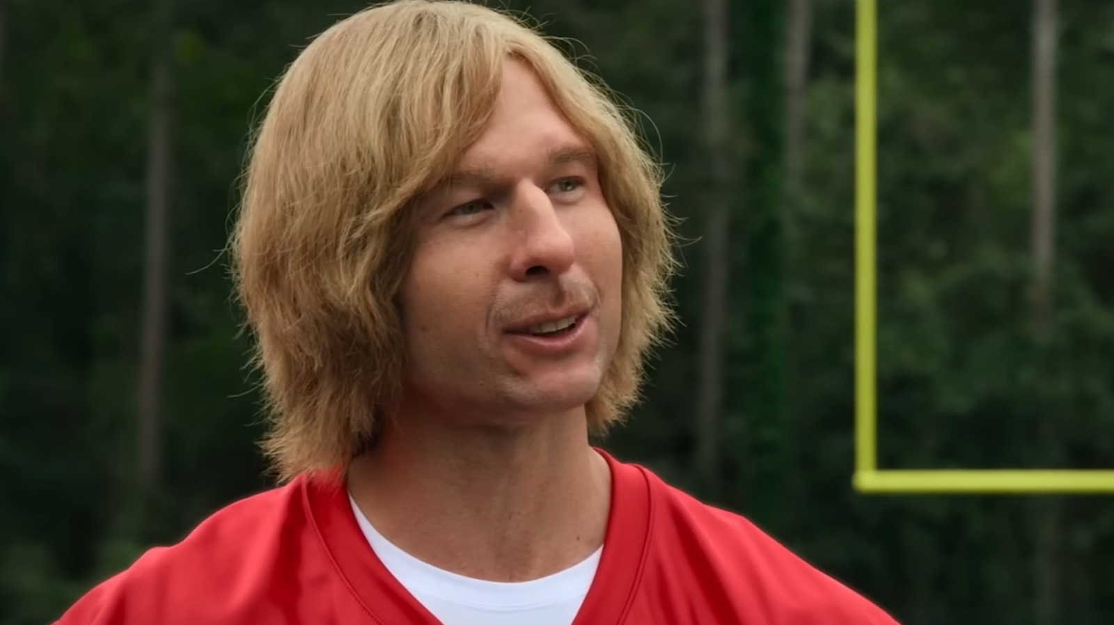 Glen Powell under make up as on a football field