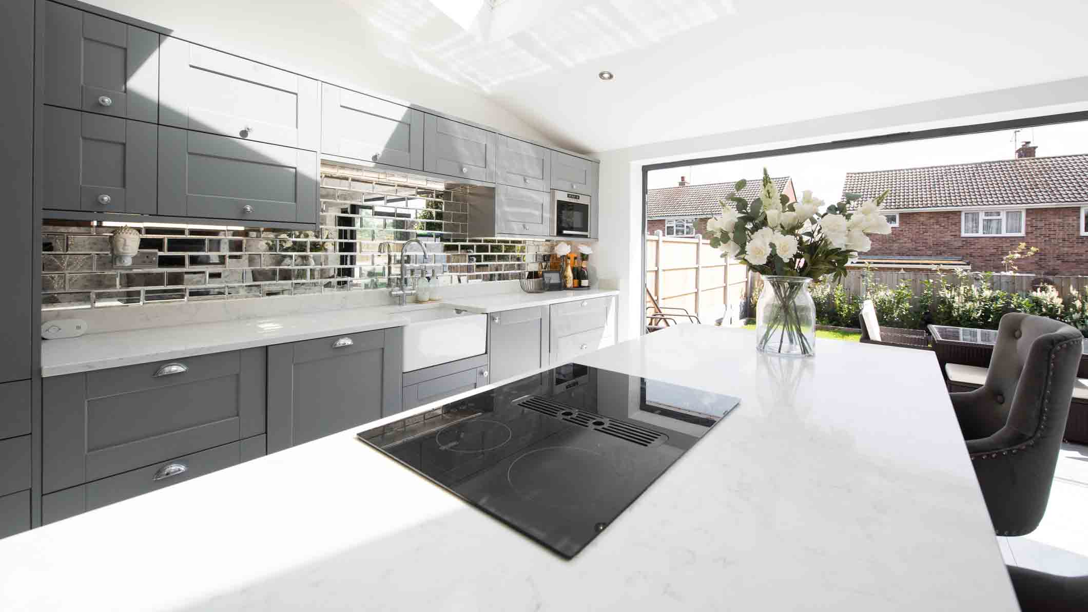 An image of a white kitchen with a black electric cooktop