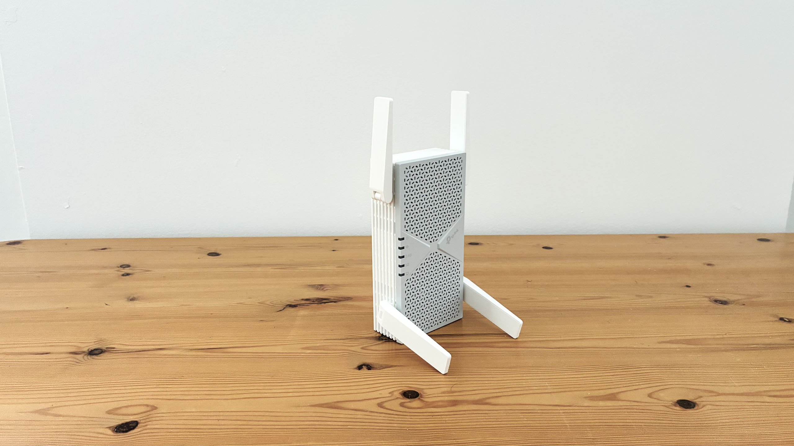 TP-Link BE6300 Wi-Fi extender on wooden desk