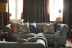 A sofa in a living room layered with traditional floral prints