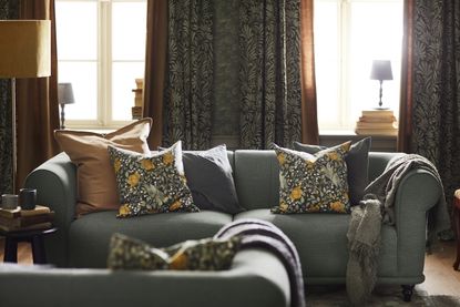 A sofa in a living room layered with traditional floral prints