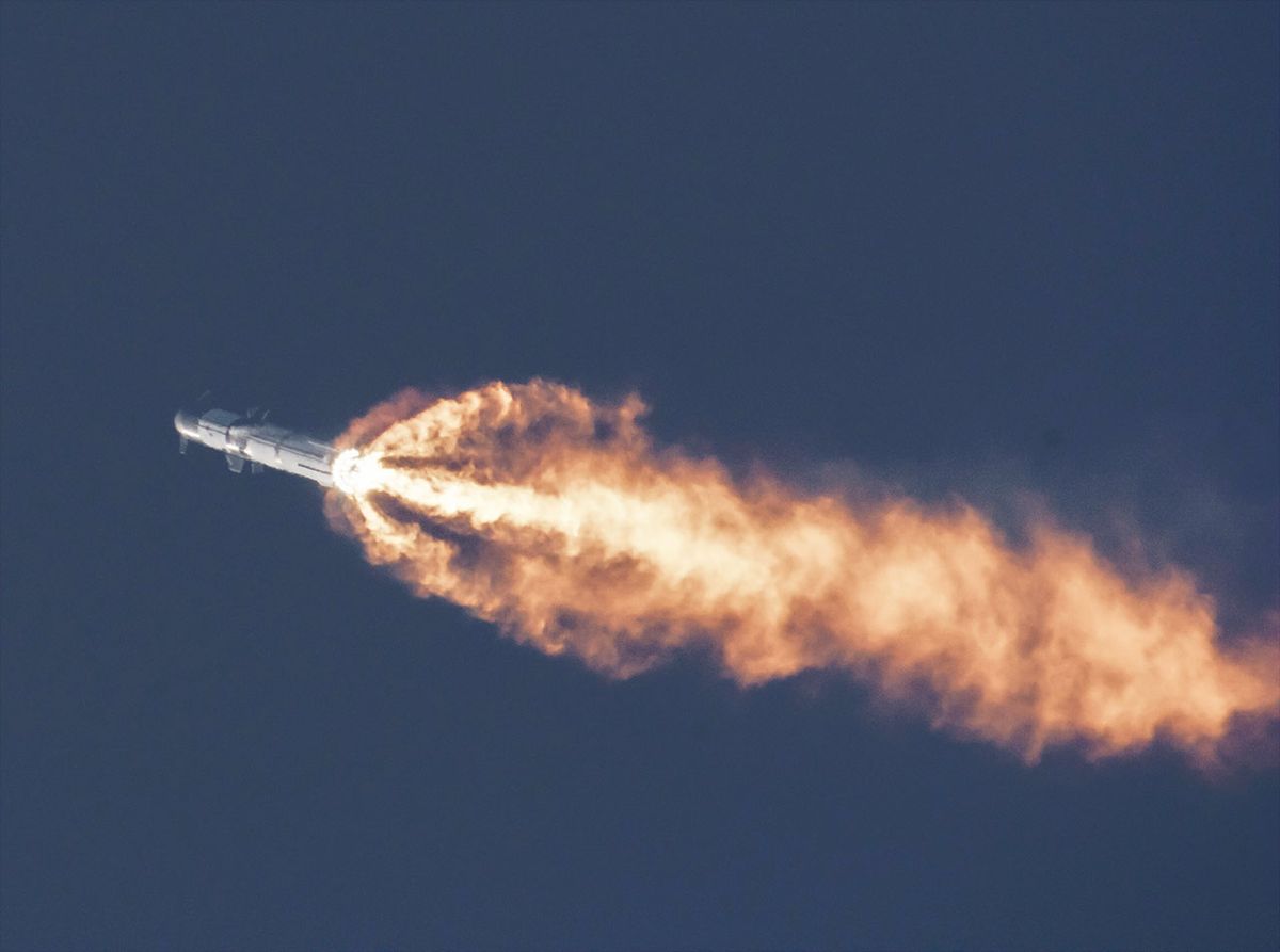 starship flying into the sky with a plume of flame underneath