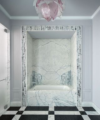 bathroom with marble finish and black and white floor