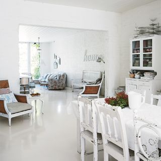open dining area with white wall and white flooring with dining table and white chairs