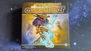 A board game box featuring a futuristic-looking alien-type creatures is placed on a starry background.