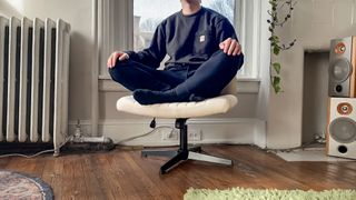 A person sitting cross-legged in an office chair