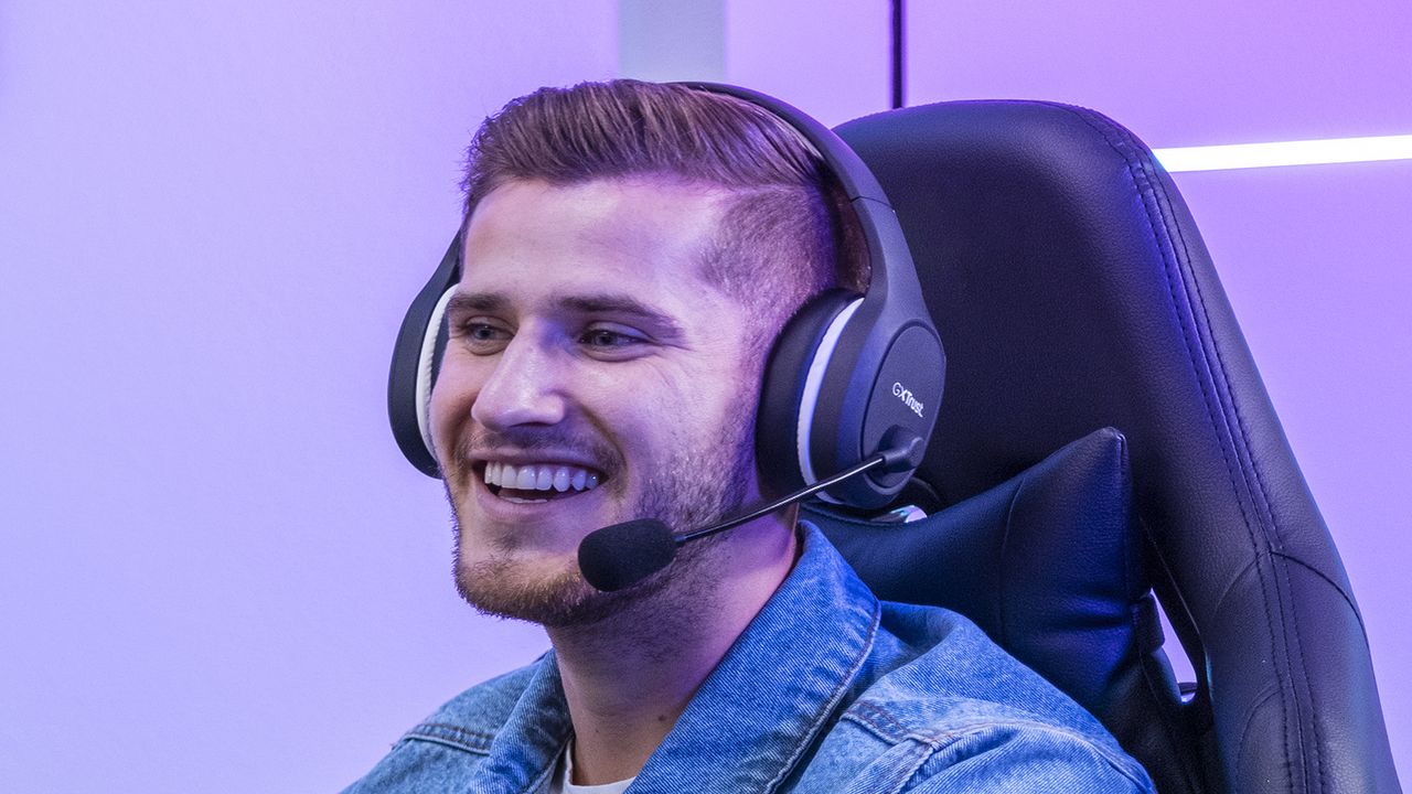 Trust Thian gaming headset being worn by a man with a beard who is sat in a gaming chair and smiling