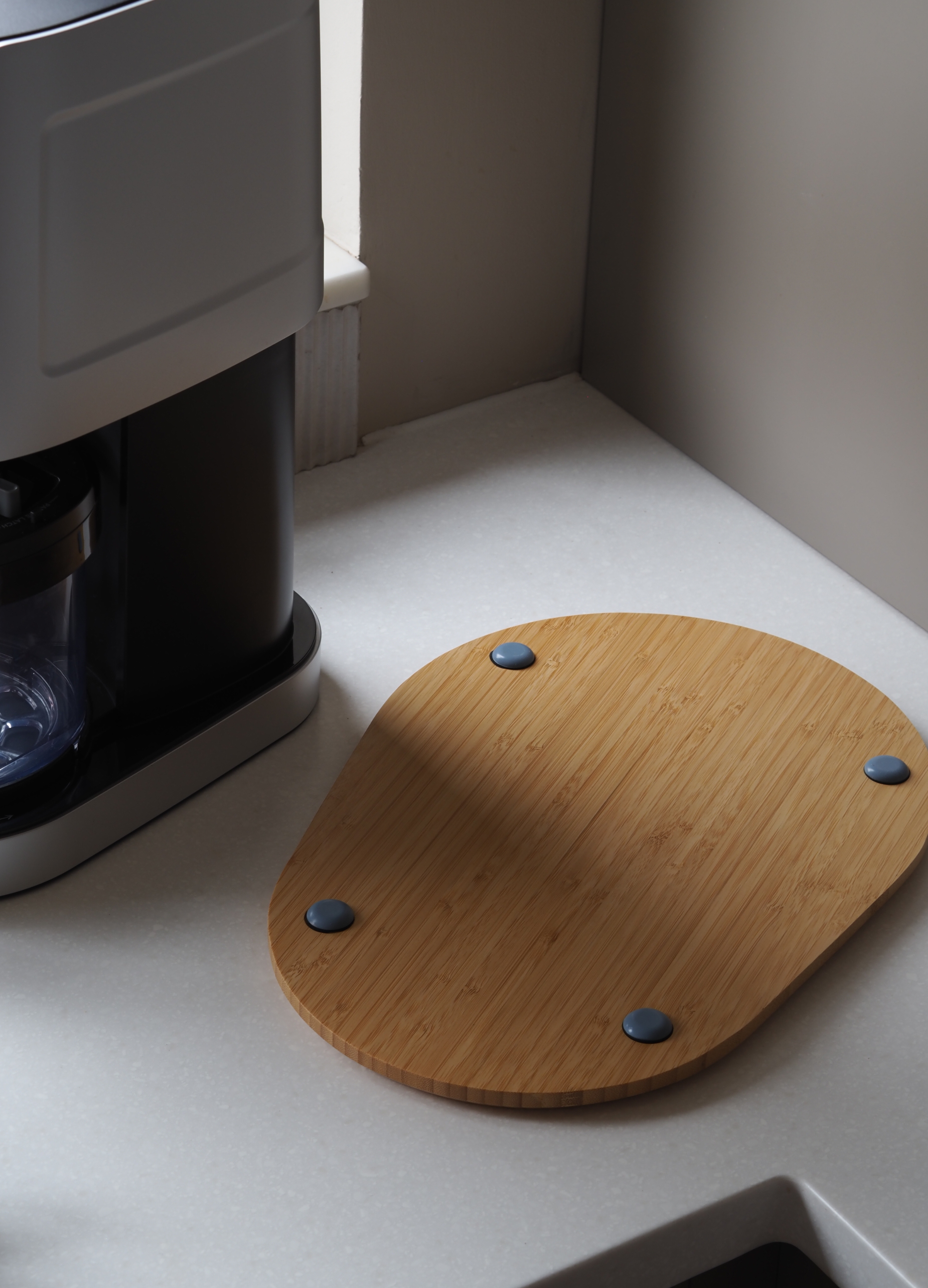 a wood board sliding on a countertop with an appliance on top