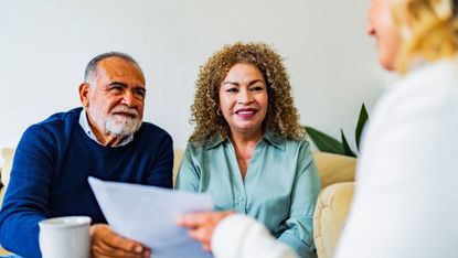 Senior couple talking to financial advisor at home
