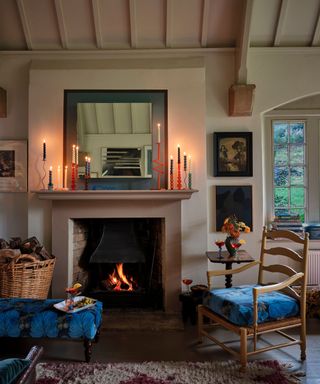 earthy rustic living room with a fireplace and log burner with accents of blue and lit candles