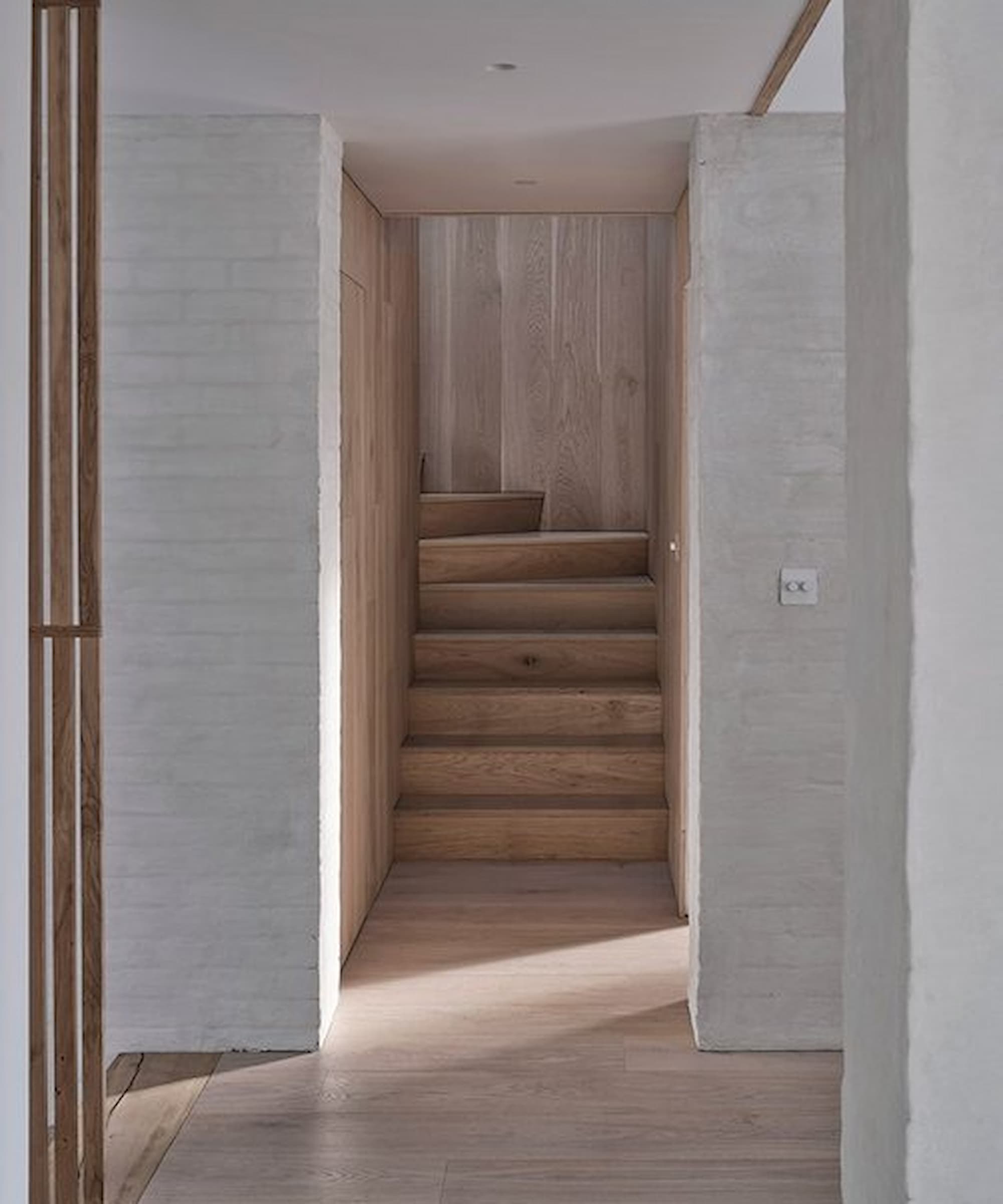 A wooden staircase that bends round to the corner
