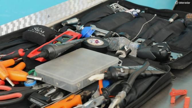 Amongst this Astana mechanic's tool case is a fork dropout on a wire for setting the QR gaps on spare wheels and assisting a faster change