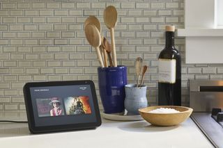 Amazon Echo Show 5 on kitchen counter near utensils and bottle of oil