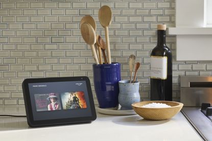 Amazon Echo Show 8 on kitchen counter near utensils and bottle of oil