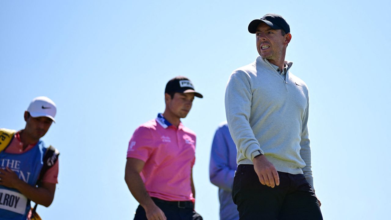 Northern Ireland&#039;s Rory McIlroy (R) and Norway&#039;s Viktor Hovland (C) leave the 12th tee during a practice round for 151st British Open Golf Championship at Royal Liverpool