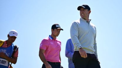 Northern Ireland's Rory McIlroy (R) and Norway's Viktor Hovland (C) leave the 12th tee during a practice round for 151st British Open Golf Championship at Royal Liverpool
