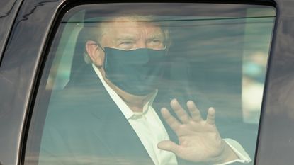 A car with US President Trump drives past supporters in a motorcade outside of Walter Reed Medical Center in Bethesda, Maryland on October 4, 2020.