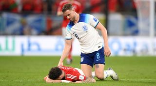 England midfielder Jordan Henderson checks on Wales' Neco Williams after the full-back takes a blow to the head in the teams' World Cup clash in Qatar.