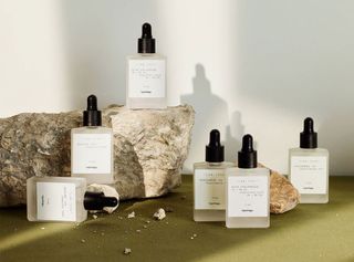 Opaque bottles of Typology skincare products displayed on granite rock