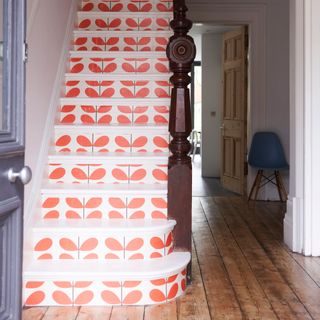 red patterned wallpaper on vertical of stairs in hallway