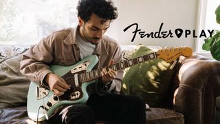 Fender Play review: Man plays an electric guitar sat on the couch