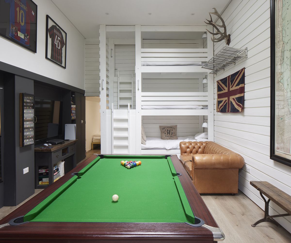 Three tier bunk bed in a games room with pool table and TV. a guest room/games room