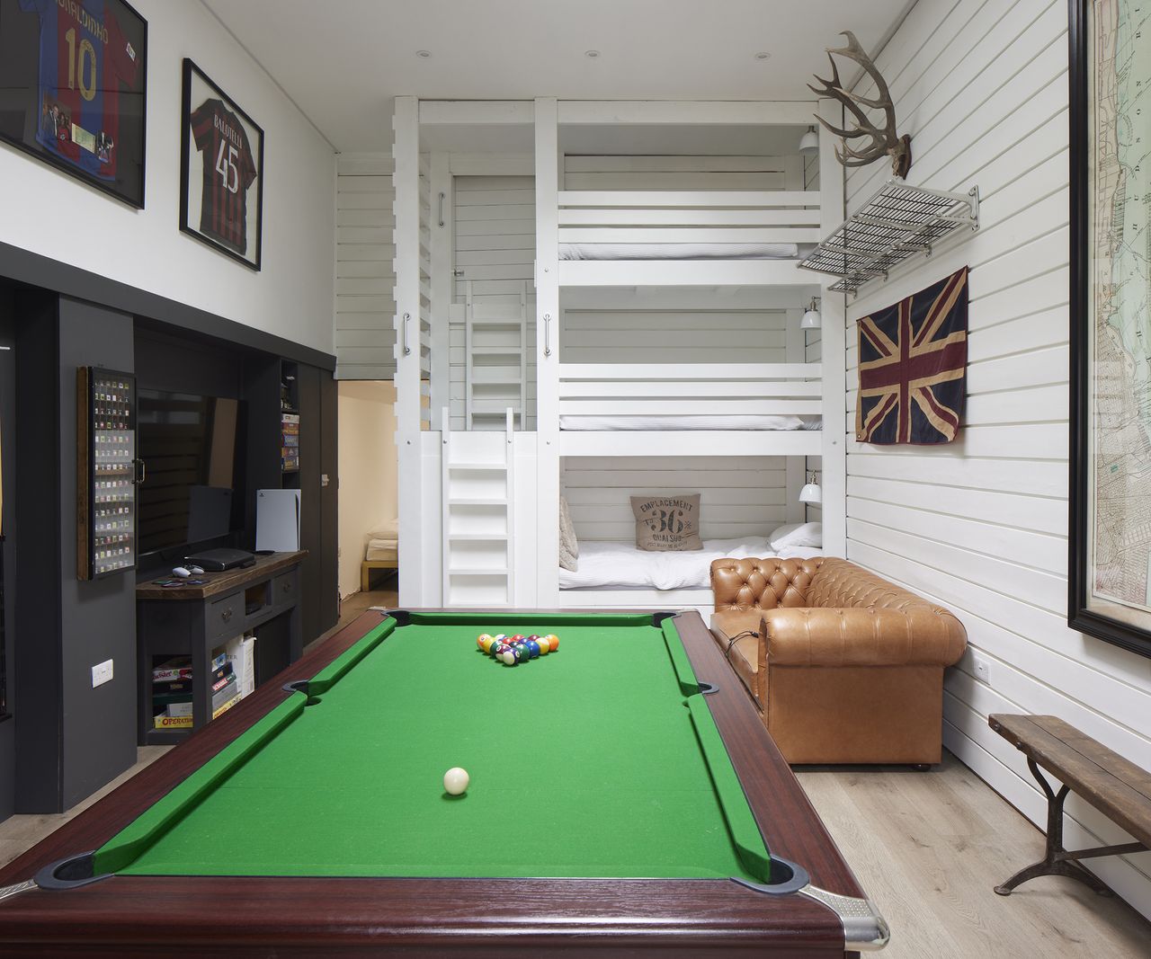 Three tier bunk bed in a games room with pool table and TV. a guest room/games room