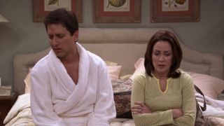 Ray Romano and Patricia Heaton sitting on a hotel bed on Everybody Loves Raymond