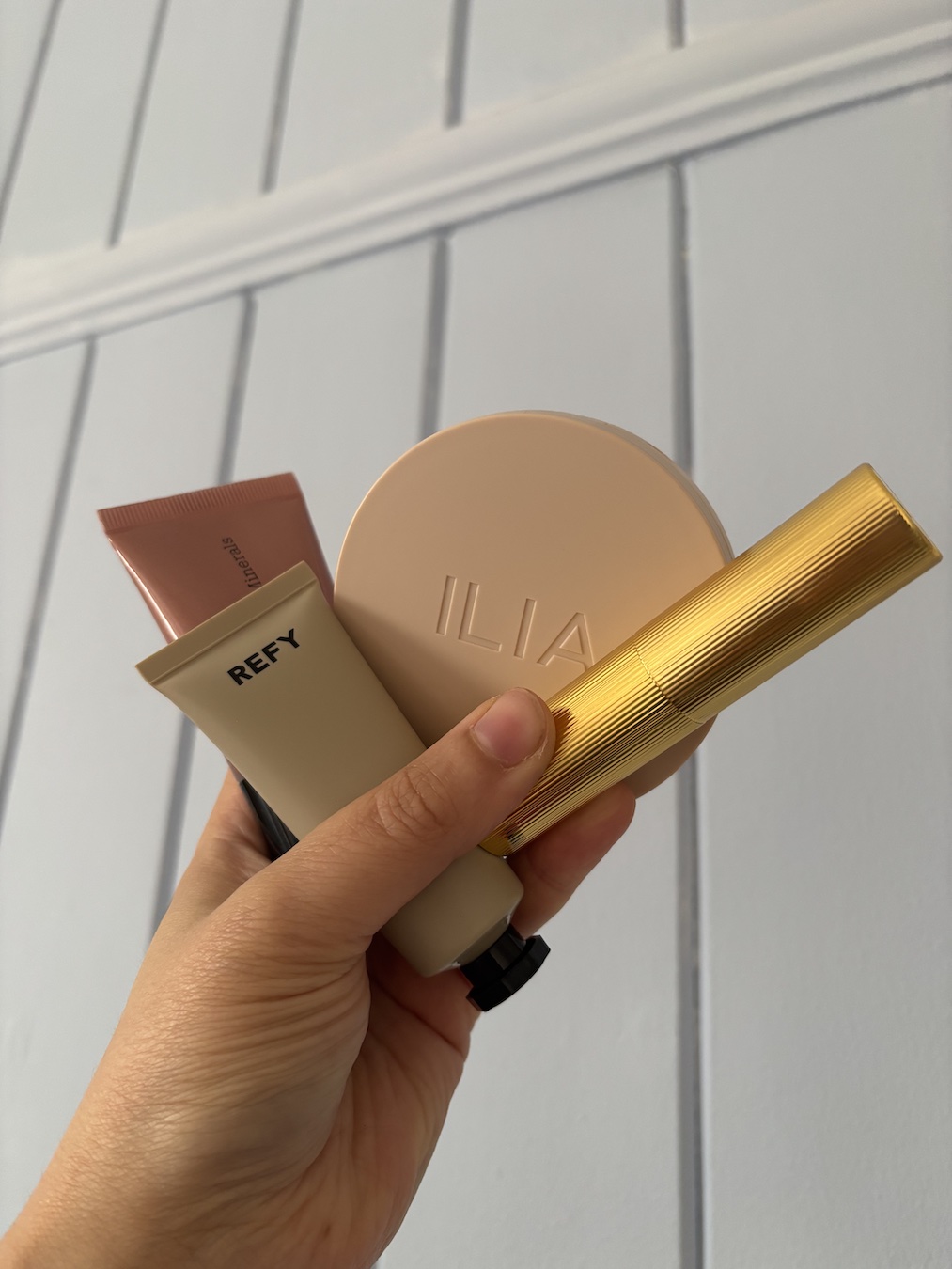 Mica Ricketts holding selection of the best cream highlighters