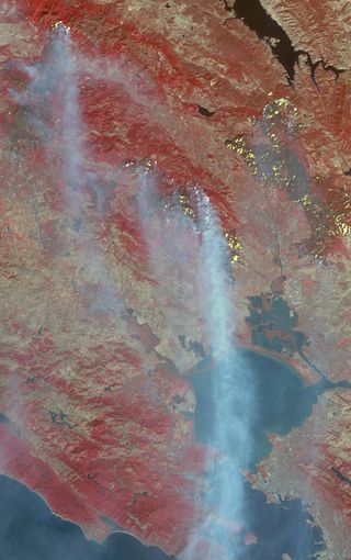 The Advanced Spaceborne Thermal Emission and Reflection Radiometer (ASTER) instrument on NASA's Terra satellite acquired this image of California's wildfires and smoke plumes on the morning of Oct. 12. The red color represents vegetation, while fires and hotspots are depicted in yellow.