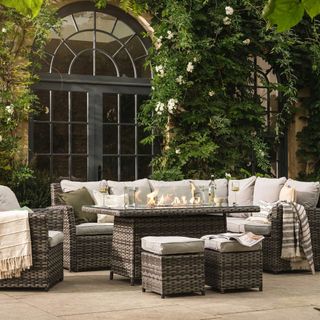 A rattan outdoor lounge set on a paved patio
