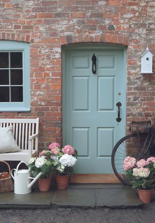 cottage front door painted in pale blue with matching window frame.jpg
