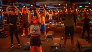 Barry’s Bootcamp class performing champagne press with dumbbells