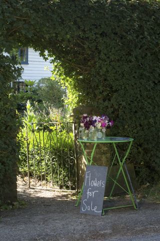 flowers for sale on table at entrance to summer garden