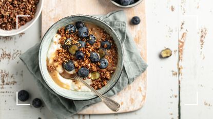 Bowl of healthy cereal with muesli and fruit on wooden chopping board, an example of what to eat for those wondering is cereal healthy