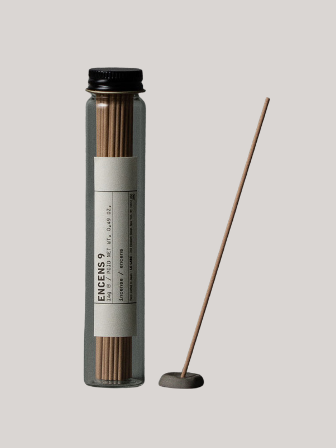 A bottle of incense sticks and a round holder from Le Labo