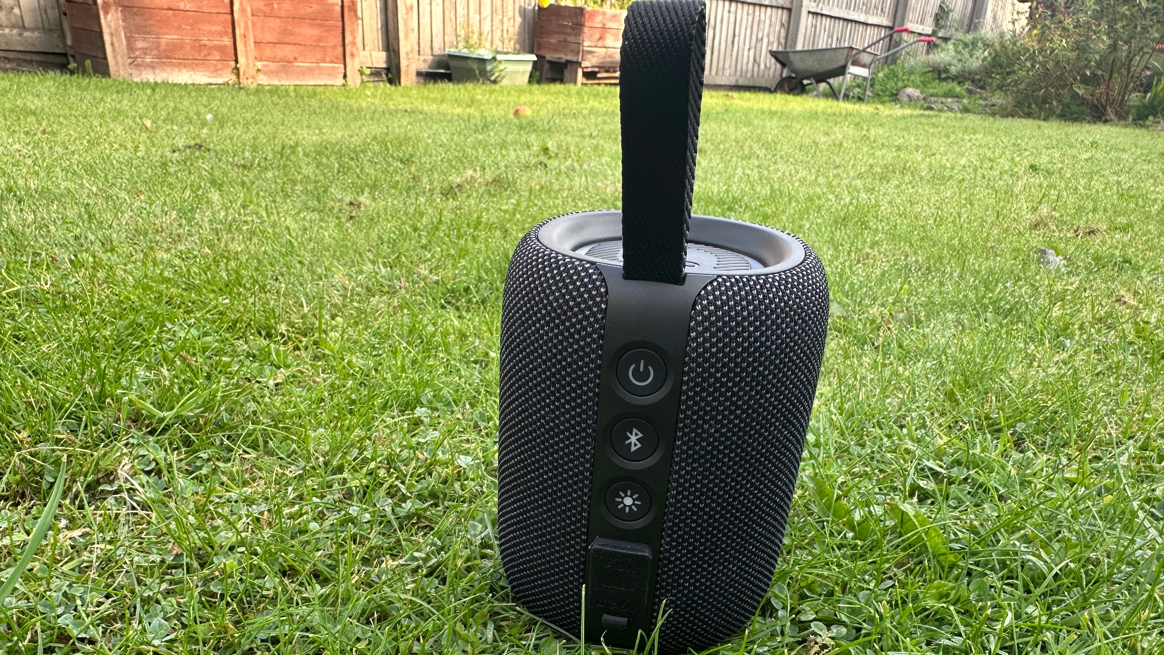 Tribit Stormbox Mini Plus Bluetooth rear panel and buttons, on a grass surface