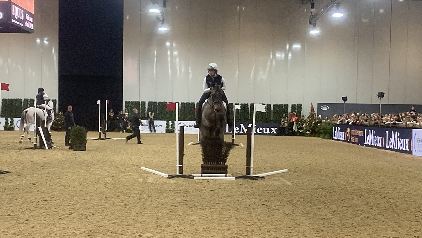Training with Dickie Waygood and Laura Collett. Megan Elphick and Winnie jump a skinny during a session at London Horse Show 2024