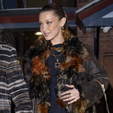 Bella Hadid steps out of Matsuhisa in Aspen with her boyfriend, Adan Banuelos, following a cozy dinner, looking radiant in a dark brown fur-lined coat with multicolored detailing. She paired it with a sleek black mini dress, semi-sheer tights, and knee-high burgundy leather boots. The couple, dating for over a year, looked happy and relaxed as they made their way through the snowy evening.