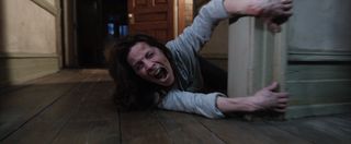 a woman screaming and being pulled around the corner in The Conjuring