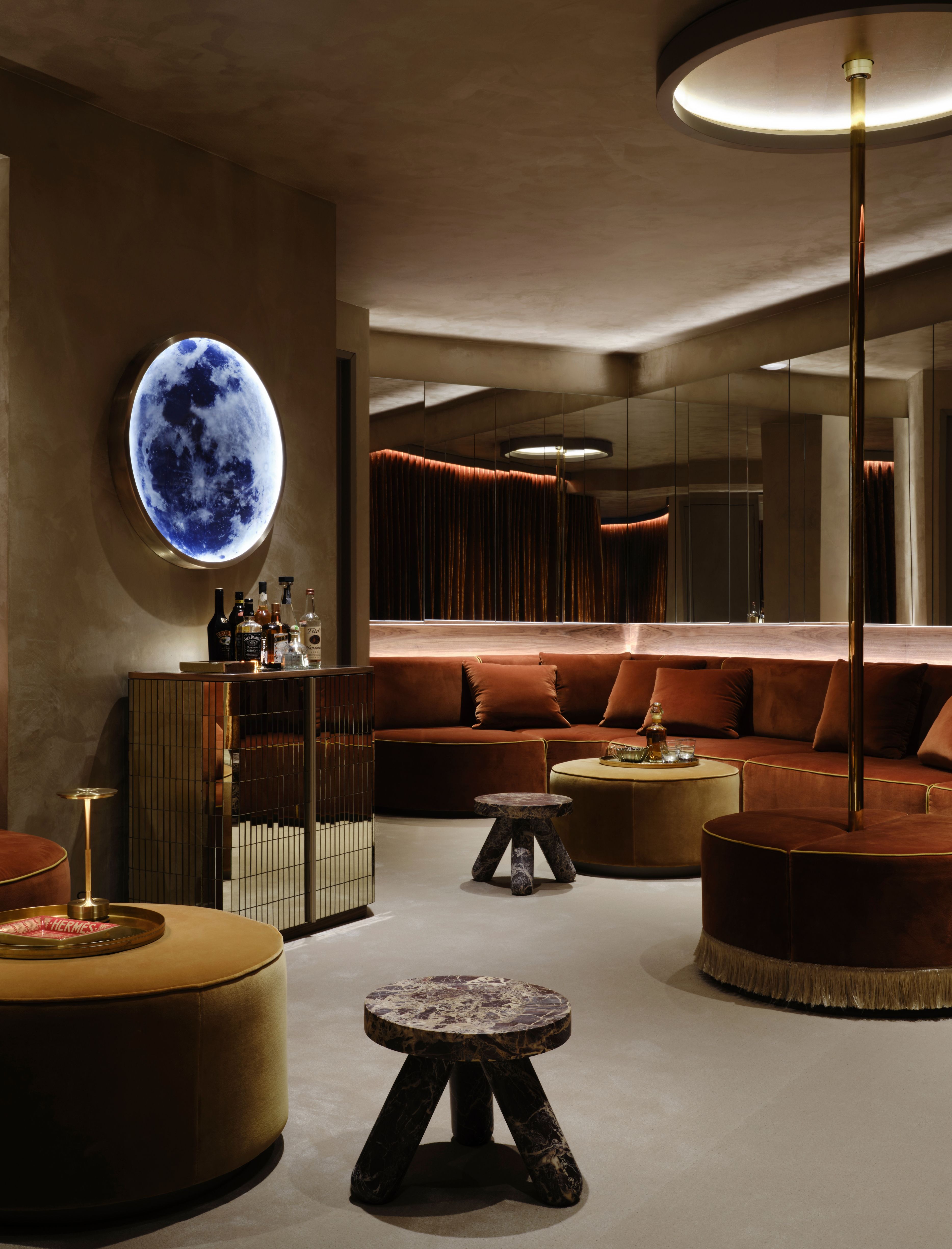 a club room in a hosue with moody lighting and a stripper pole