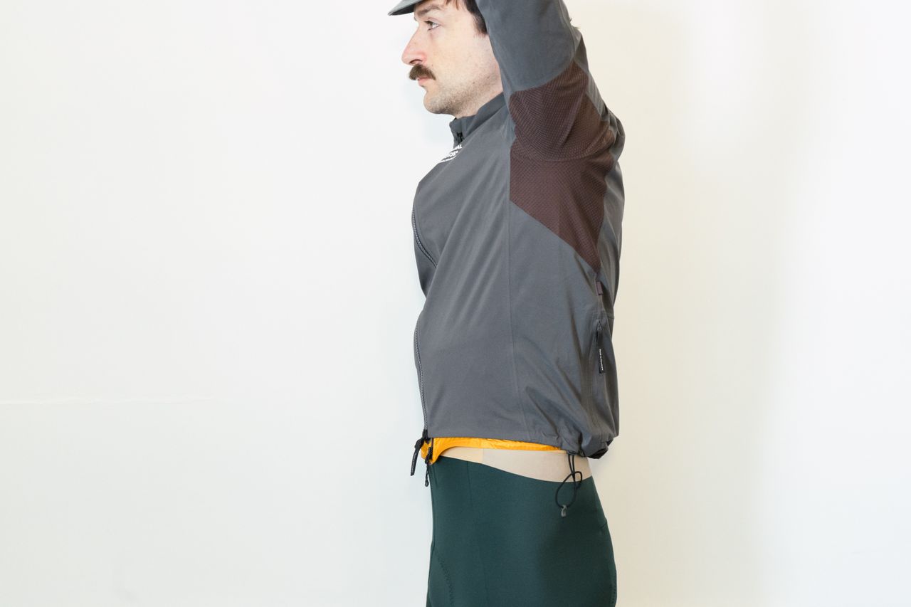 A white man in a grey jacket simulates different riding positions