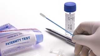 A DNA paternity test with a swab and gloved hand