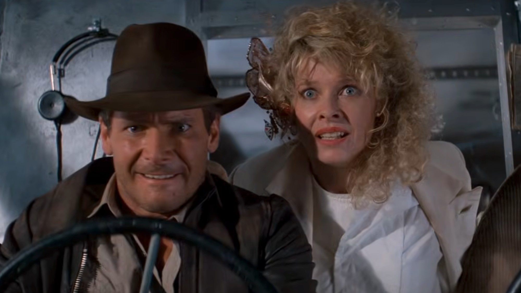 Harrison Ford as Indiana Jones flying a plane with Kate Capshaw looking stressed out in Temple of Doom.