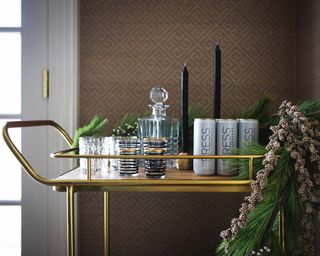 gold bar cart with navy candles, PRESS cans and greenery
