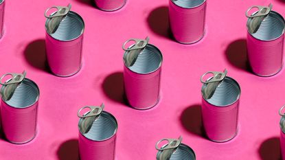 Top view of repeated tin cans on pink background -